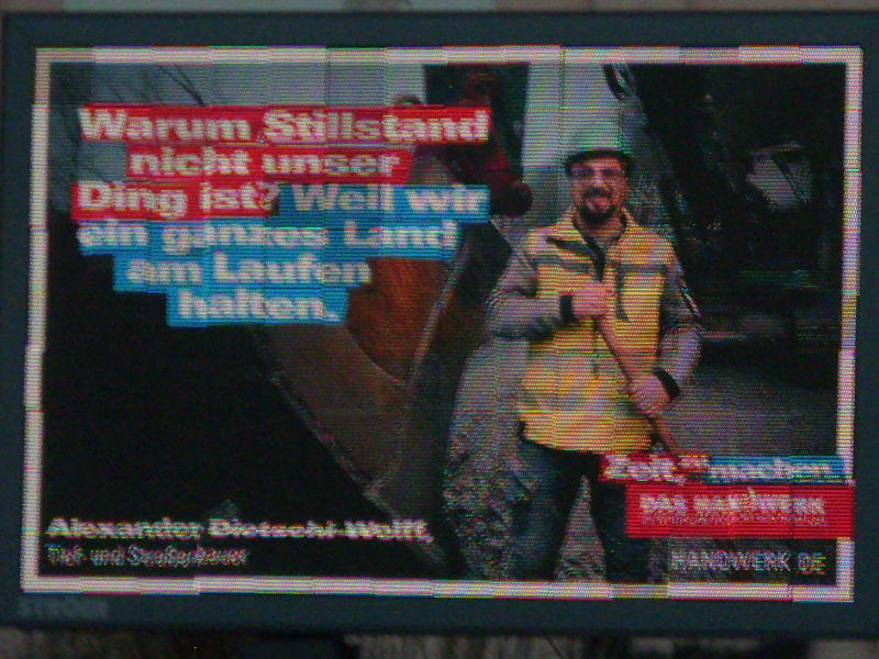 Verpixelte Displayreklame mit einem Mann neben einer Baggerschaufel und dem Text „Warum Stillstand nicht unser Ding ist? Weil wir ein ganzes Land am Laufen halten. Alexander Dietschi-Wolff, Tief und Straßenbau. Zeit zu machen. DAS HANDWERK. HANDWERK.DE“